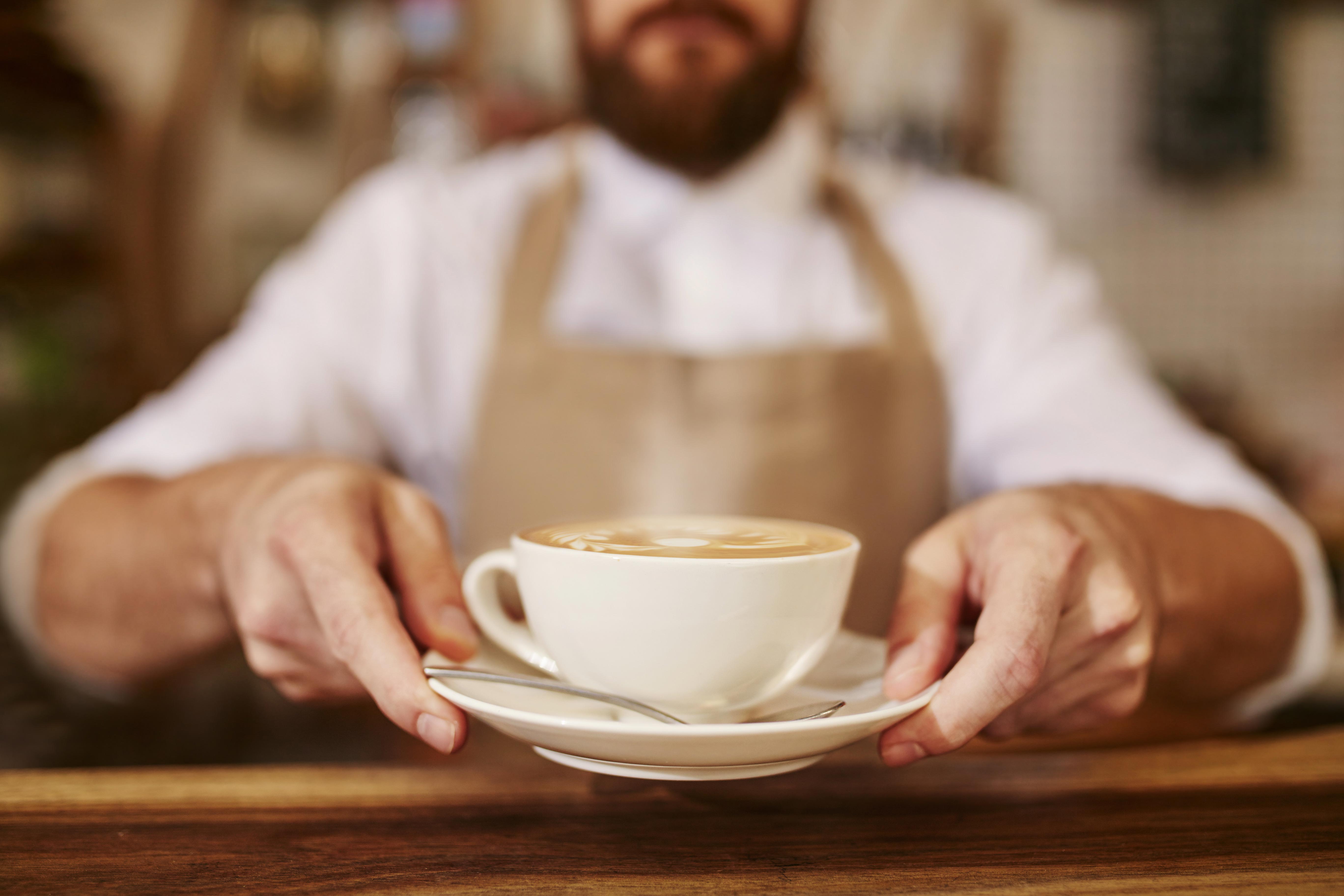 Man holding a cup of cappuccino